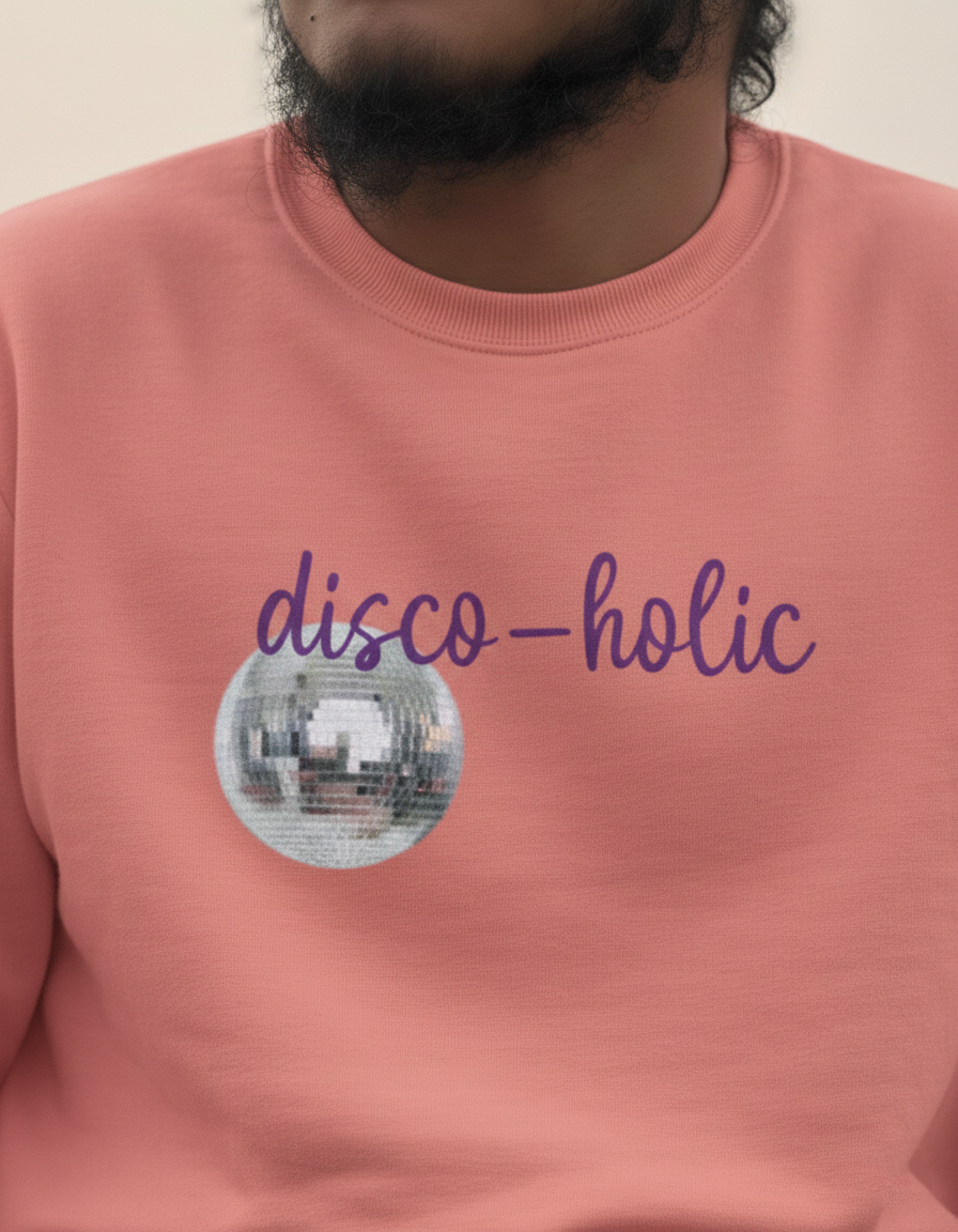 Person wearing a pink sweatshirt with 'disco-holic' design and disco ball graphic.