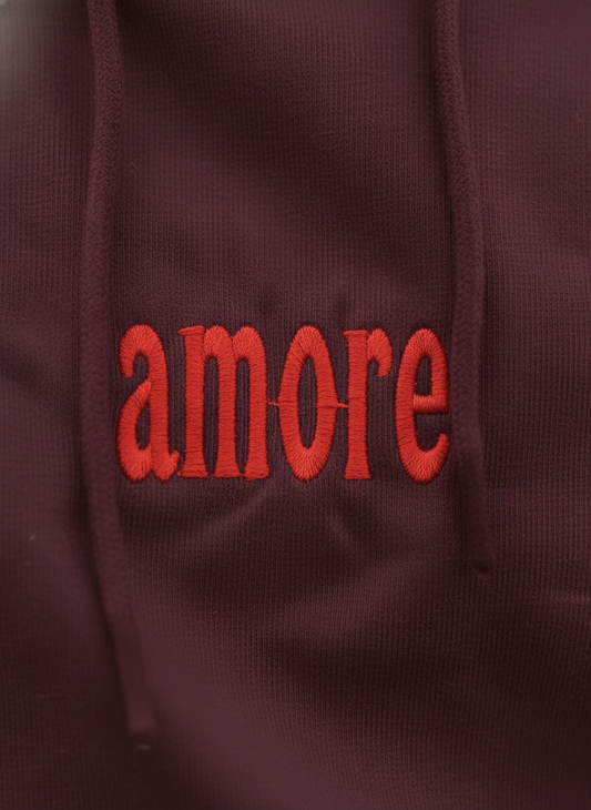 Maroon hoodie with red 'amore' text on a close-up view